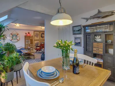 a dining room with a table with a bottle of wine at The Salt Loft in Fowey