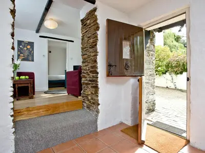 a living room with a stone wall and a door at Stables - Uk31176 in Saint Martin