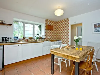 a kitchen with a wooden table and white cabinets at Stables - Uk31176 in Saint Martin
