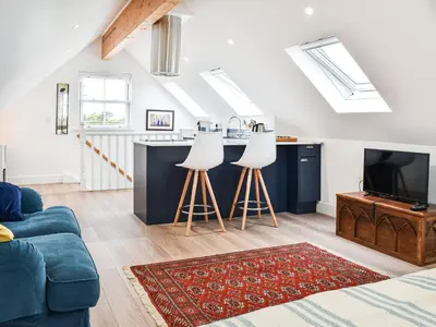 a living room with a couch and a tv at Elmington Studio in Tintagel