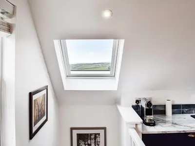 a skylight in a white room with a window at Elmington Studio in Tintagel