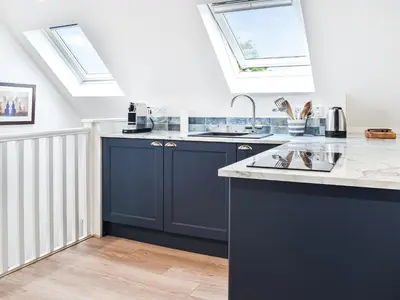 a kitchen with blue cabinets and a sink and skylights at Elmington Studio in Tintagel
