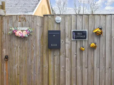a wooden fence with a bee cottage sign on it at Bee Cottage in Hayle
