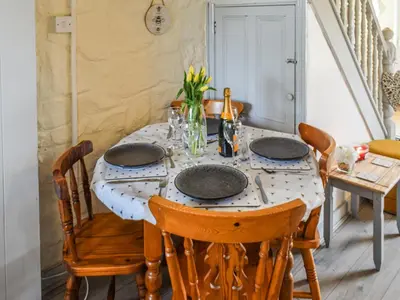 a dining room with a table with plates and chairs at Bee Cottage in Hayle