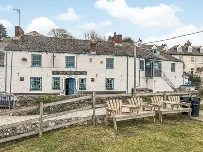 a white building with chairs in front of it at The Steps in Pentewan