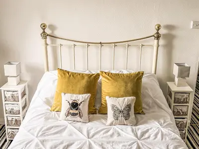 a bed with white sheets and pillows on it at The Steps in Pentewan
