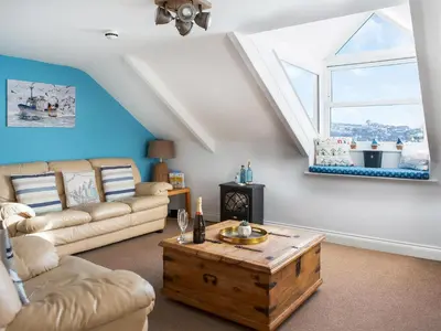 a living room with a couch and a table at The Wheelhouse in Fowey