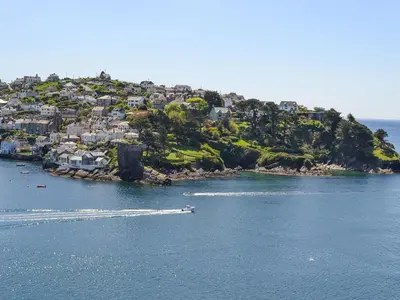 an island in the water with houses and a boat at The Wheelhouse in Fowey