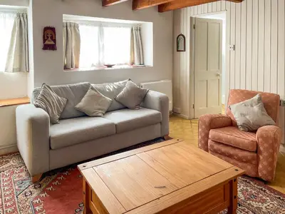 a living room with a couch and a chair at Zion Cottage in St Austell