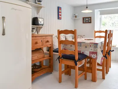 a kitchen with a table and chairs and a dining room at Zion Cottage in St Austell
