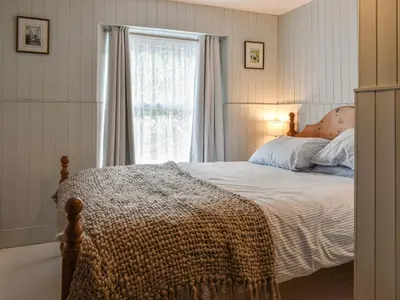 a bedroom with a bed and a window at Zion Cottage in St Austell