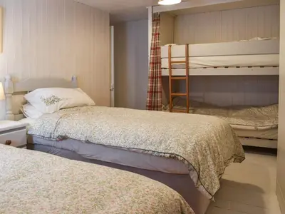 a bedroom with two beds and a bunk bed at Zion Cottage in St Austell
