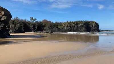 a beach with rocks in the water and sand at Beach Base Lodge, Padstow Cornwall in Padstow