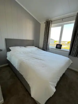 a bedroom with a large white bed with a window at Beach Base Lodge, Padstow Cornwall in Padstow