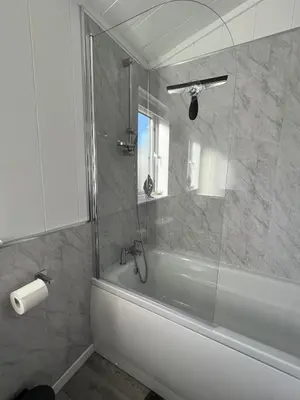 a bathroom with a tub and a glass shower at Beach Base Lodge, Padstow Cornwall in Padstow