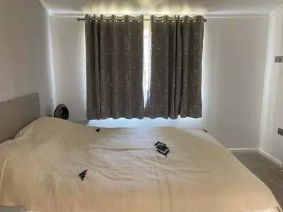 a bedroom with a large white bed with a window at Beach Base Lodge, Padstow Cornwall in Padstow