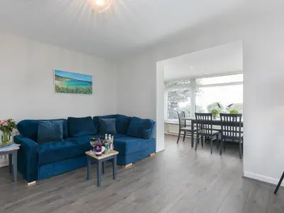a living room with a blue couch and a table at The Pines in St Ives