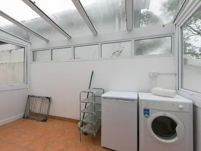 a laundry room with a washing machine and a window at The Pines in St Ives