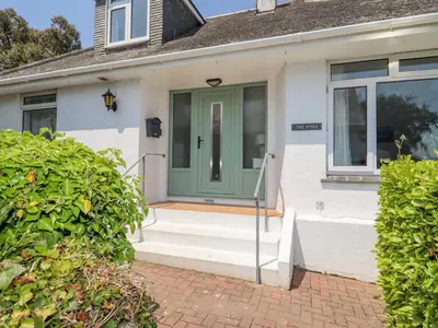 a front door of a white house with a green door at The Pines in St Ives