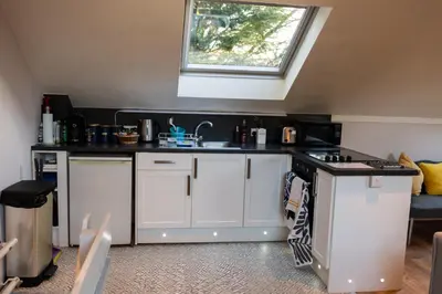 a kitchen with white cabinets and a window at 1 Bedroom studio with free parking in Truro