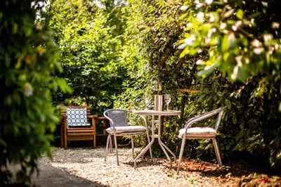two chairs and a table in a garden at 1 Bedroom studio with free parking in Truro