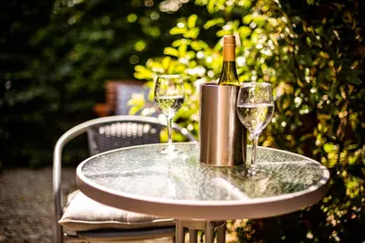 a table with a bottle of wine and two glasses at 1 Bedroom studio with free parking in Truro