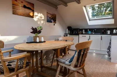 a kitchen with a wooden table and chairs at 1 Bedroom studio with free parking in Truro
