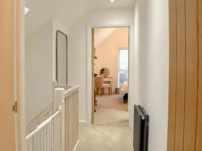a hallway with a stairway leading to a living room at Little Trevose in Padstow