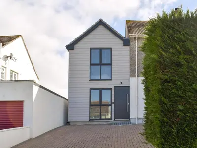 a white house with a blue garage at Little Trevose in Padstow