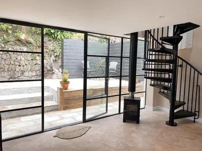 a living room with a spiral staircase and glass windows at Luxury bolthole in central St.Agnes with parking. in St. Agnes
