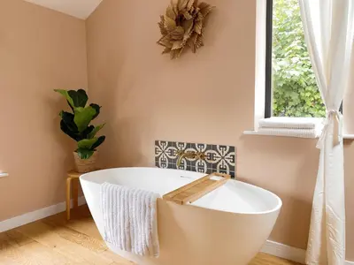 a bath tub in a bathroom with a window at Luxury bolthole in central St.Agnes with parking. in St. Agnes