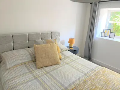 a bed with yellow pillows in a bedroom with a window at Your luxurious and secluded retreat in Cornwall in Helston