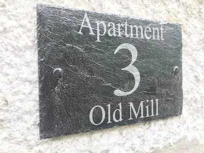 a sign for an old mill on the side of a building at Your luxurious and secluded retreat in Cornwall in Helston