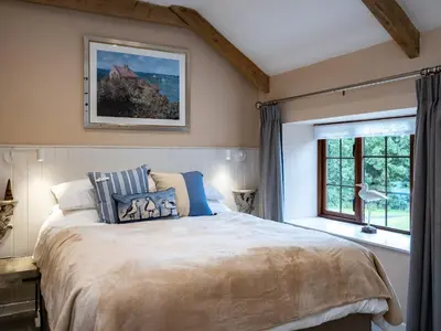 a bedroom with a large bed and a window at The Snug in Wadebridge