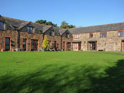 a large brick building with a large lawn in front of it at The Snug in Wadebridge