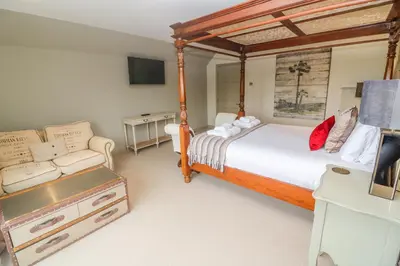 a bedroom with a canopy bed and a couch at Bodmin Country House in Bodmin