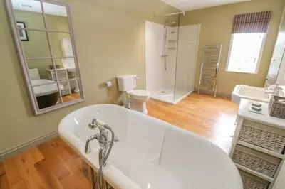 a bathroom with a tub and a sink and a mirror at Bodmin Country House in Bodmin