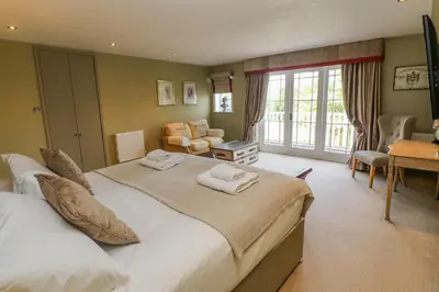 a bedroom with a large bed and a living room at Bodmin Country House in Bodmin