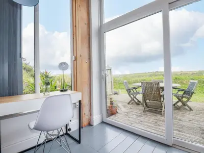 a room with a window and a table and chairs at Three Gables in Newquay