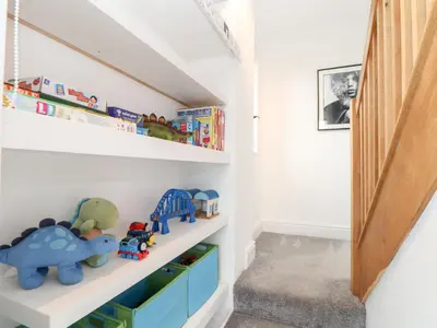 a childs room with white walls and white shelves with toys at Three Gables in Newquay