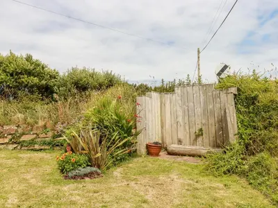 a wooden fence in a yard with some plants at Three Gables in Newquay