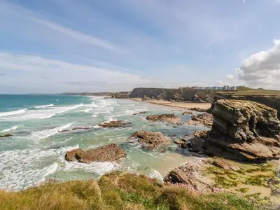 a view of a beach with rocks and the ocean at Three Gables in Newquay