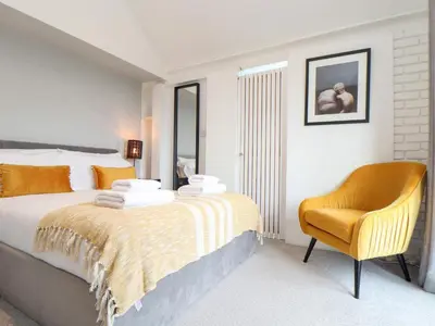 a bedroom with a bed and a chair at Three Gables in Newquay
