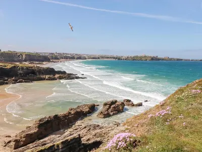 a view of a beach with rocks and the ocean at Three Gables in Newquay