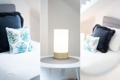 a room with blue and white pillows and a table with a lamp at Len's Lookout in St Ives