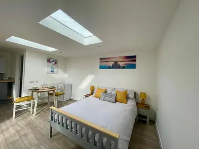 a bedroom with a bed and a table and a skylight at The Little Hideaway in Truro
