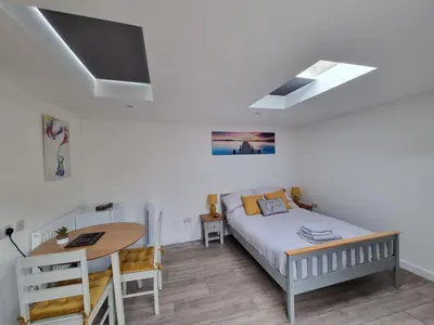 a bedroom with a bed and a desk and a table at The Little Hideaway in Truro