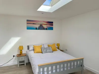 a bedroom with a white bed with yellow pillows at The Little Hideaway in Truro