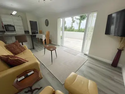 a living room with a couch and a table and a television at Sunnyside Cow Shed one bedroom central Cornwall in Truro