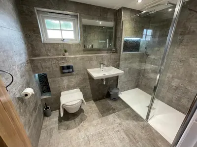 a bathroom with a shower toilet and a sink at Sunnyside Cow Shed one bedroom central Cornwall in Truro